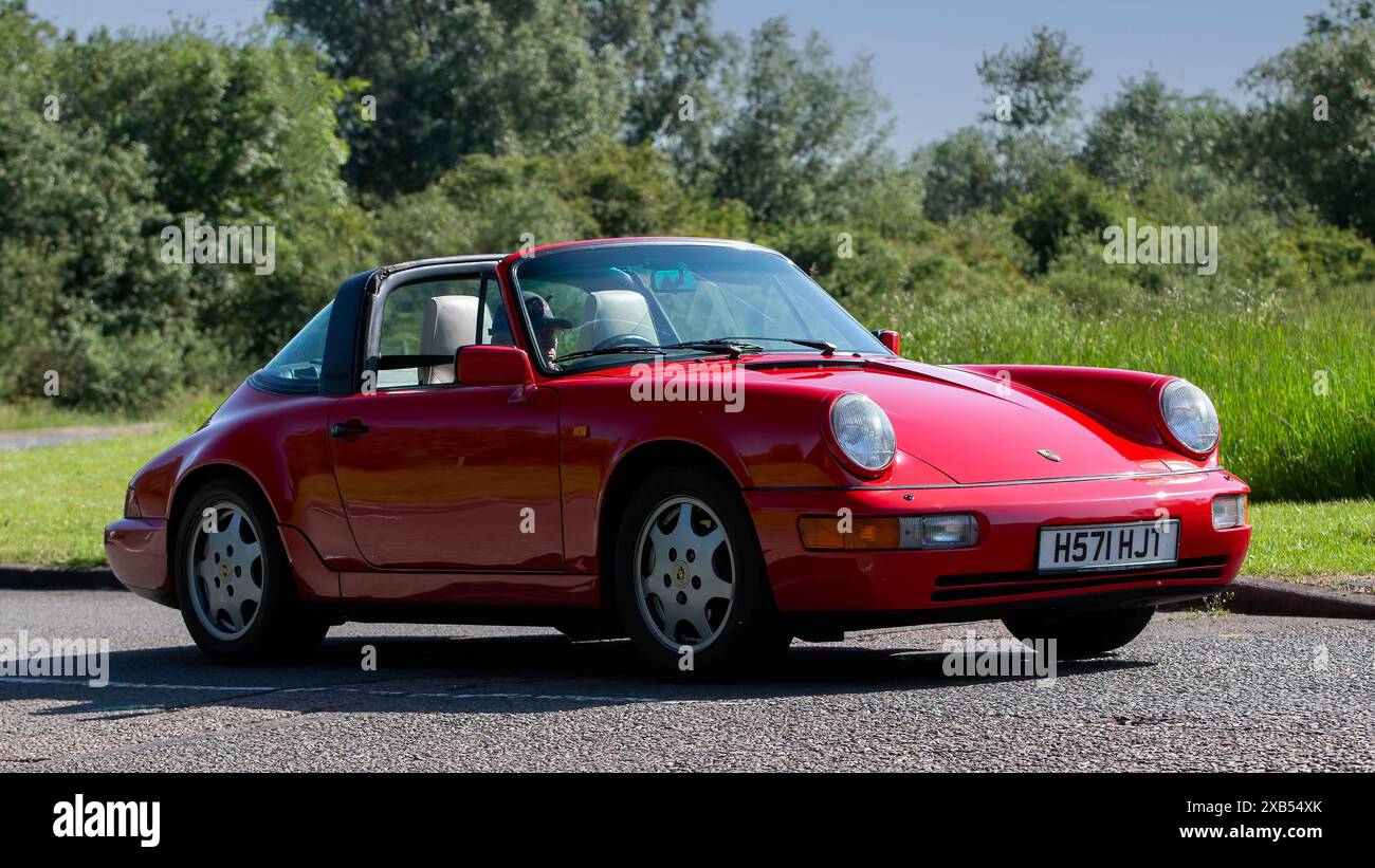 Stony Stratford, Regno Unito - 2 giugno 2024: 1990 Porsche 911 rossa, auto d'epoca che guida su una strada di campagna britannica Foto Stock