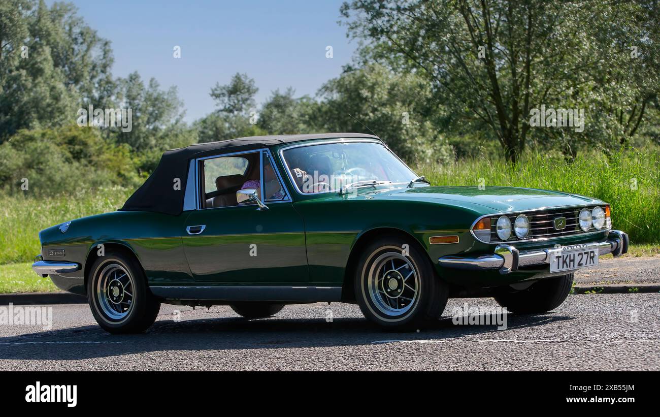 Stony Stratford, Regno Unito - 2 giugno 2024: 1977 auto d'epoca verde Triumph Stag su una strada di campagna britannica Foto Stock