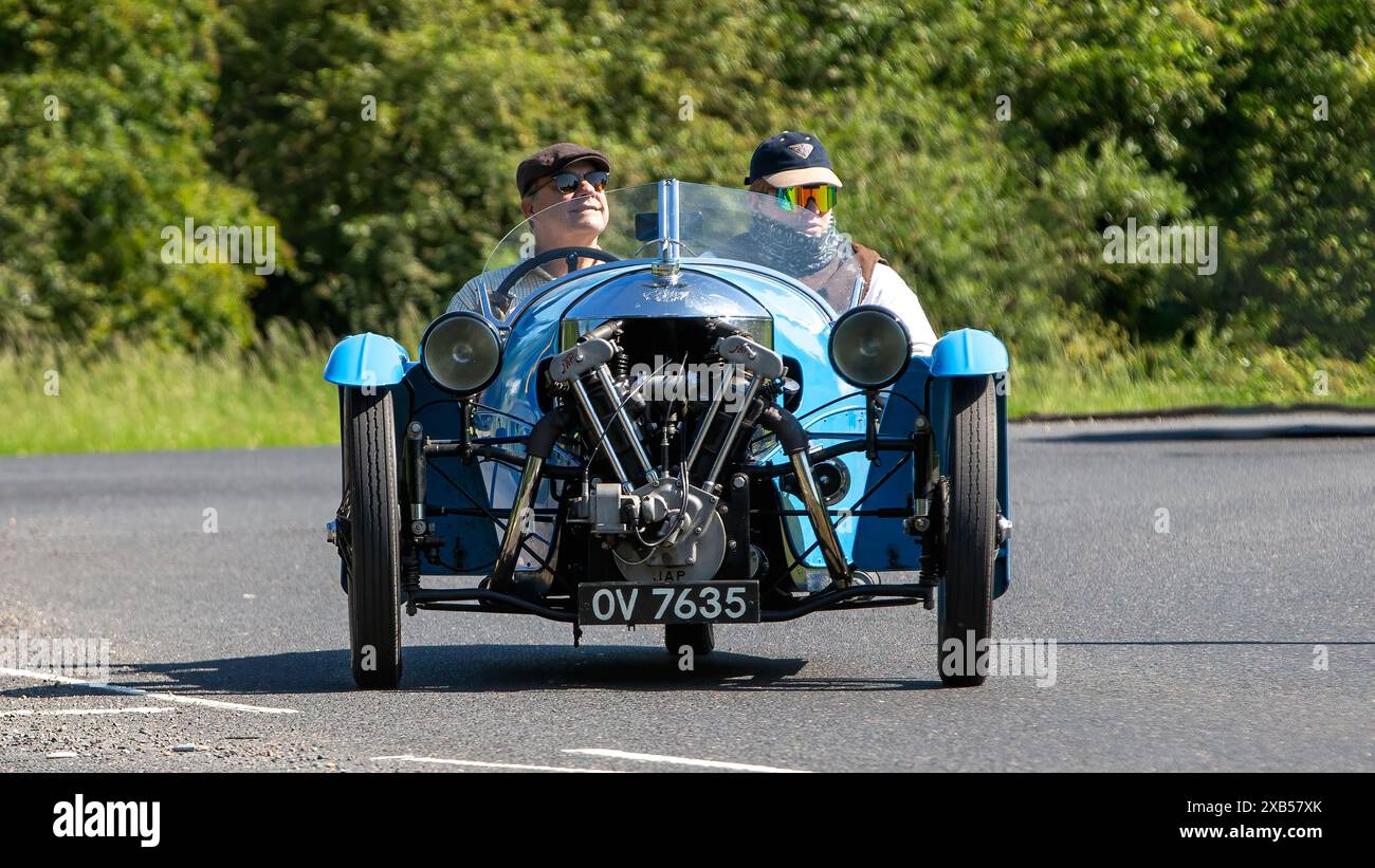 Stony Stratford, Regno Unito - 2 giugno 2024: 1932 Morgan Super Sport blu, auto d'epoca a tre ruote, su una strada di campagna britannica Foto Stock