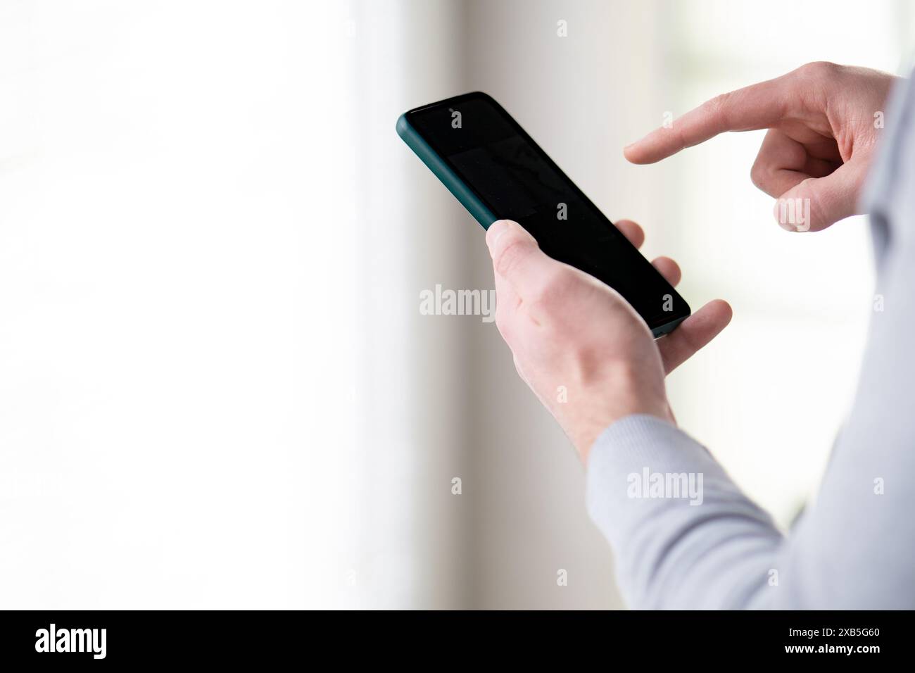 primo piano di un uomo che utilizza lo smartphone, mani maschili che tengono lo smartphone e puntano allo schermo Foto Stock