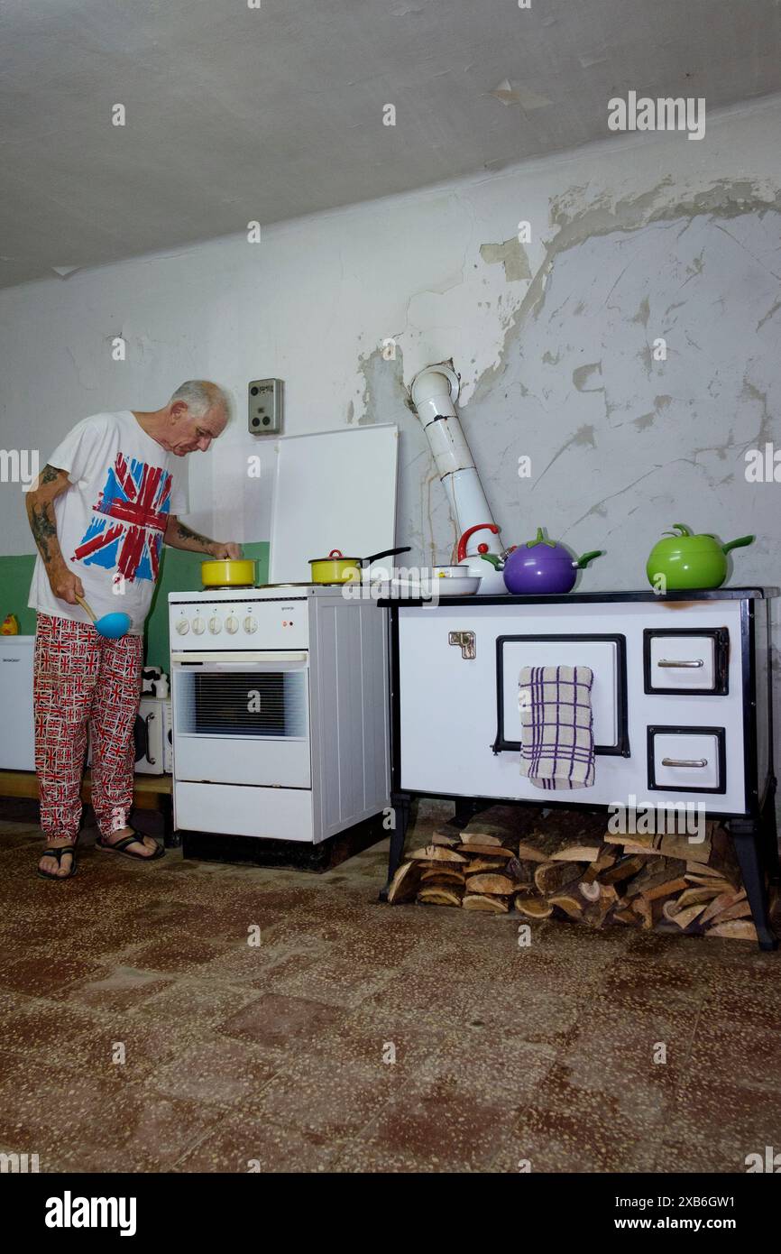 un uomo maturo britannico espone in abiti appropriati cucinando un pasto nella sua cucina per i compagni espatriati della contea di zala in ungheria Foto Stock