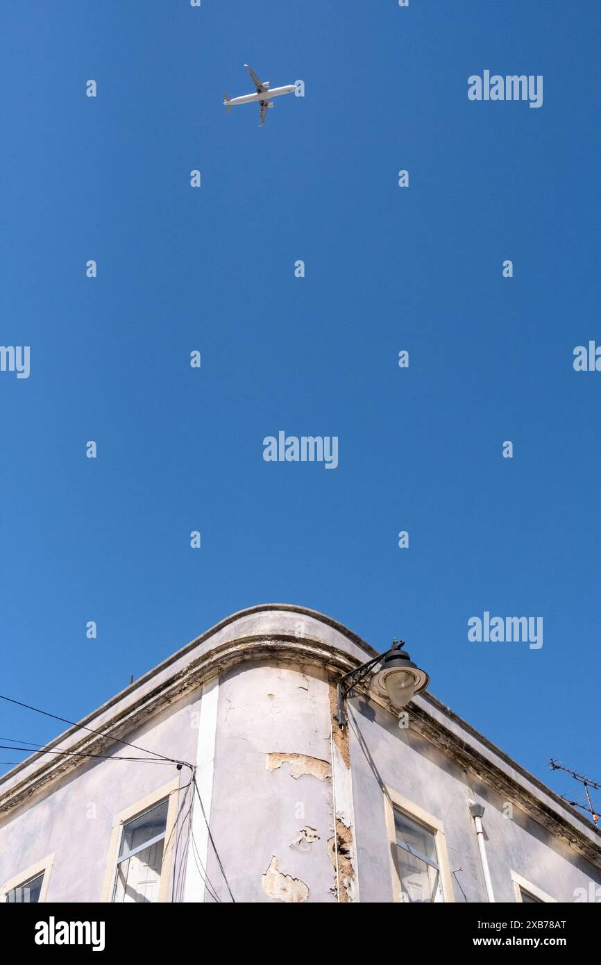 Un aereo nel cielo sopra un edificio colorato con architettura tradizionale portoghese a Lisbona, la capitale del Portogallo, il 30 aprile 2022. Un avion Foto Stock