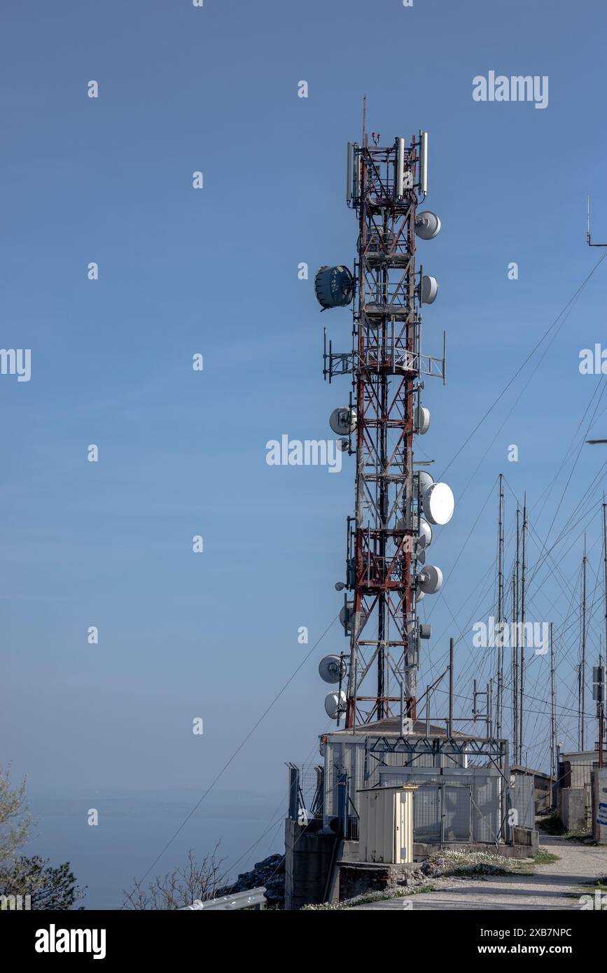 Un'alta torre cellulare con più antenne sulla parte superiore Foto Stock