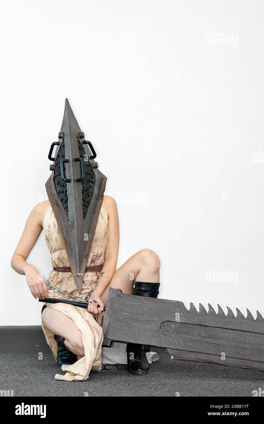 Una cosplayer donna in un costume da personaggio horror di Pyramid Head di Silent Hill, al Comic con. Foto Stock