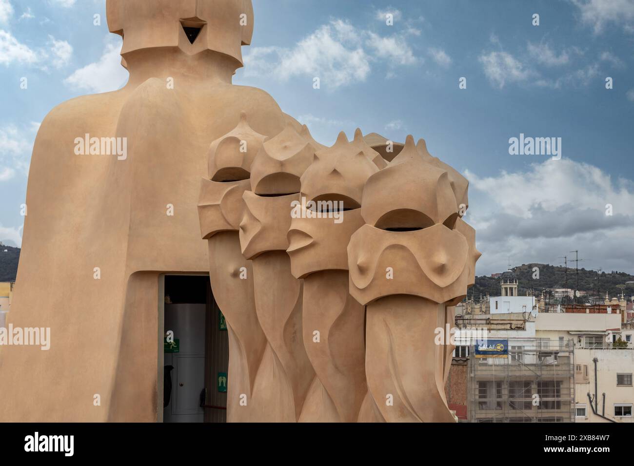 Gargoyle appollaiato sulla sporgenza vicino agli edifici con una donna Foto Stock