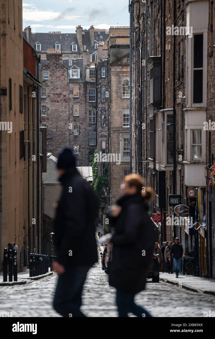 Due persone che passeggiano e una persona che cammina su una strada della città Foto Stock