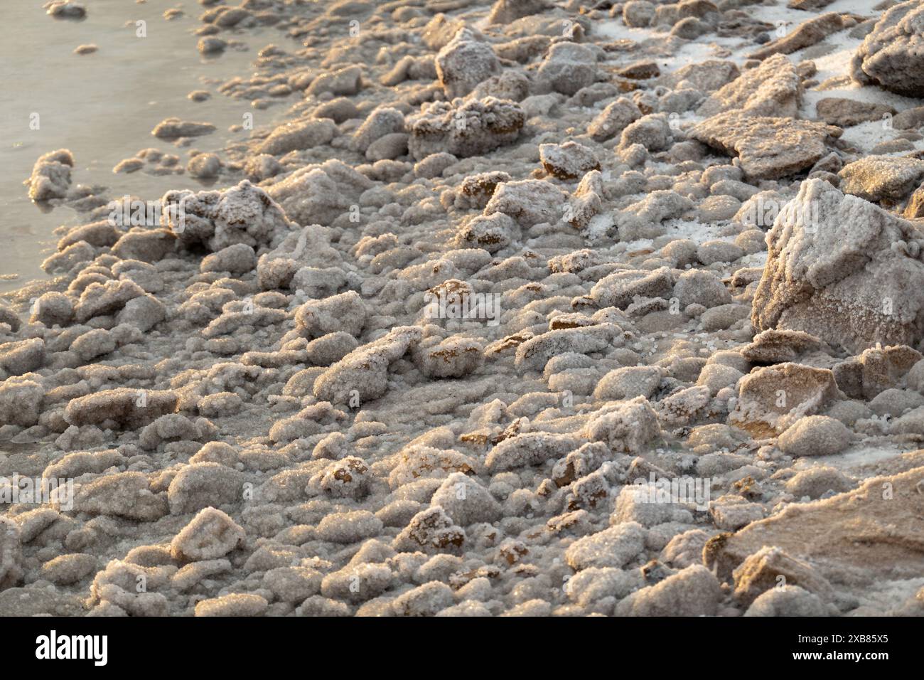 Formazioni saline naturali che coprono la costa rocciosa in riva al mare. Struttura dettagliata e vista ravvicinata del sale cristallizzato. Foto Stock