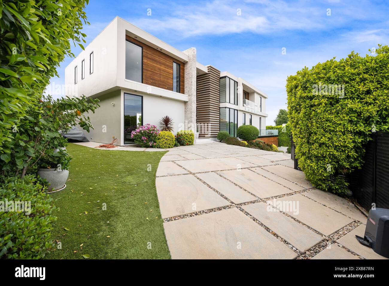 Un vialetto di una casa contemporanea con un'area giardino Foto Stock