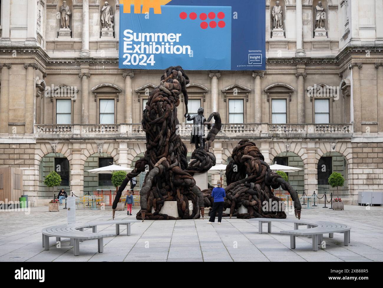 Royal Academy, Londra, Regno Unito. 11 giugno 2024. SOLO NOTIZIE EDITORIALI - quest'anno sono in mostra oltre 1200 opere d'arte nella Mostra estiva, tra cui una straordinaria scultura tessile monumentale nel cortile Annenberg (foto) di Nicola Turner, che interagisce con la statua del presidente fondatore della RA, Sir Joshua Reynolds. La Summer Exhibition presso la RA di Londra, si svolge dal 18 giugno al 18 agosto 2024 ed è la più grande mostra d'arte contemporanea aperta al mondo che si svolge ogni anno senza interruzioni dal 1769. Crediti: Malcolm Park/Alamy Live News Foto Stock