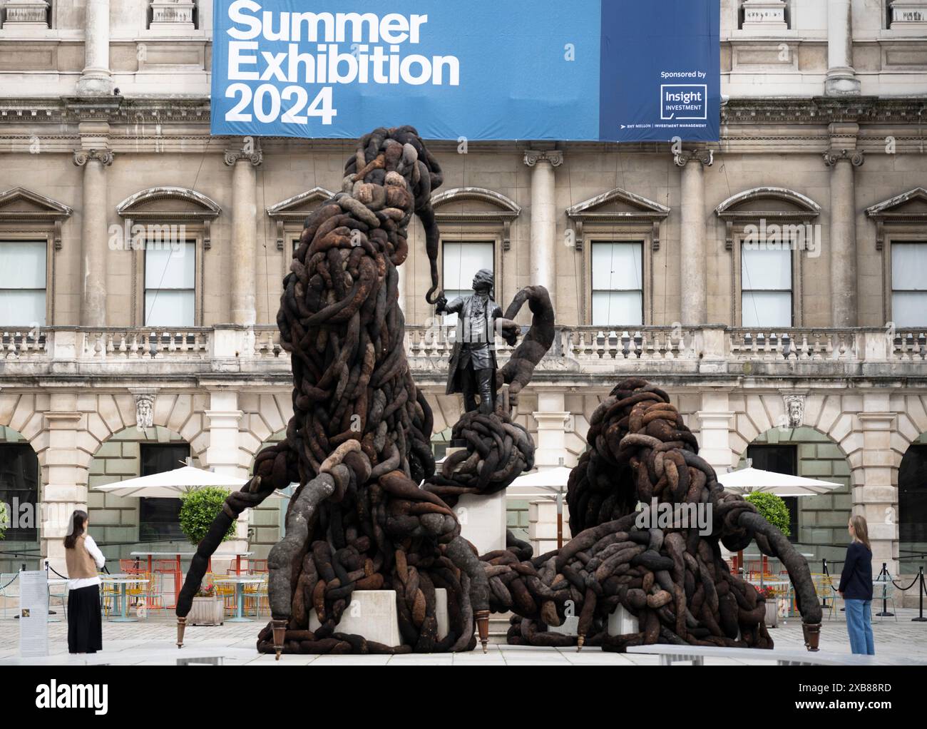 Royal Academy, Londra, Regno Unito. 11 giugno 2024. SOLO NOTIZIE EDITORIALI - quest'anno sono in mostra oltre 1200 opere d'arte nella Mostra estiva, tra cui una straordinaria scultura tessile monumentale nel cortile Annenberg (foto) di Nicola Turner, che interagisce con la statua del presidente fondatore della RA, Sir Joshua Reynolds. La Summer Exhibition presso la RA di Londra, si svolge dal 18 giugno al 18 agosto 2024 ed è la più grande mostra d'arte contemporanea aperta al mondo che si svolge ogni anno senza interruzioni dal 1769. Crediti: Malcolm Park/Alamy Live News Foto Stock