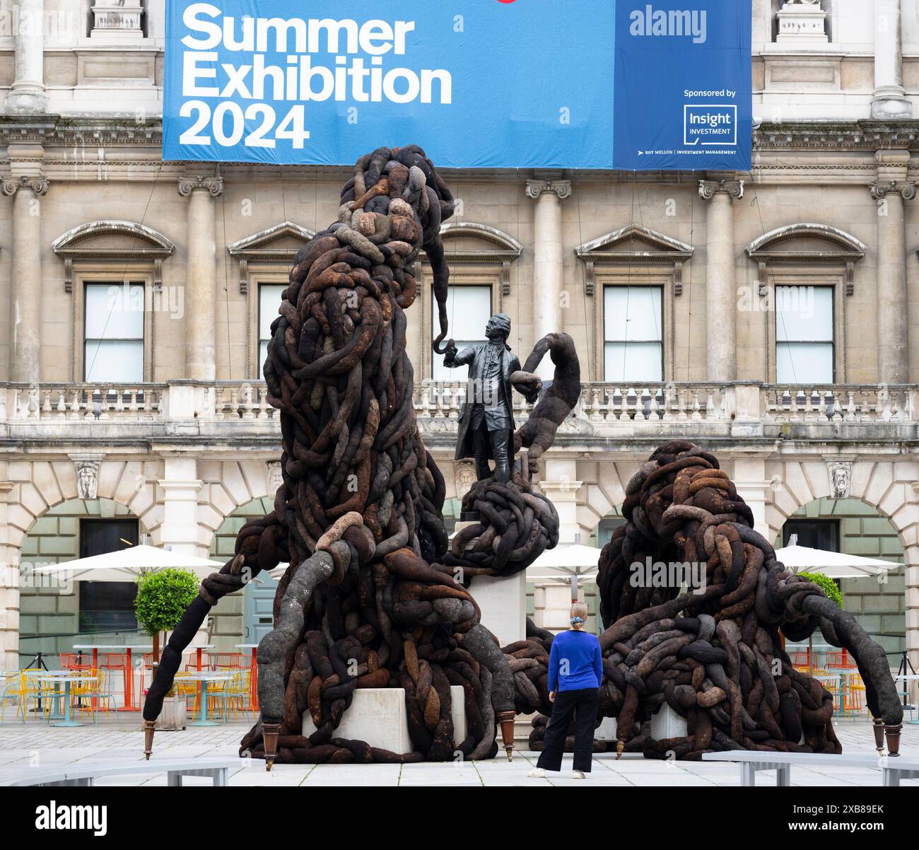 Royal Academy, Londra, Regno Unito. 11 giugno 2024. SOLO NOTIZIE EDITORIALI - quest'anno sono in mostra oltre 1200 opere d'arte nella Mostra estiva, tra cui una straordinaria scultura tessile monumentale nel cortile Annenberg (foto) di Nicola Turner, che interagisce con la statua del presidente fondatore della RA, Sir Joshua Reynolds. La Summer Exhibition presso la RA di Londra, si svolge dal 18 giugno al 18 agosto 2024 ed è la più grande mostra d'arte contemporanea aperta al mondo che si svolge ogni anno senza interruzioni dal 1769. Crediti: Malcolm Park/Alamy Live News Foto Stock