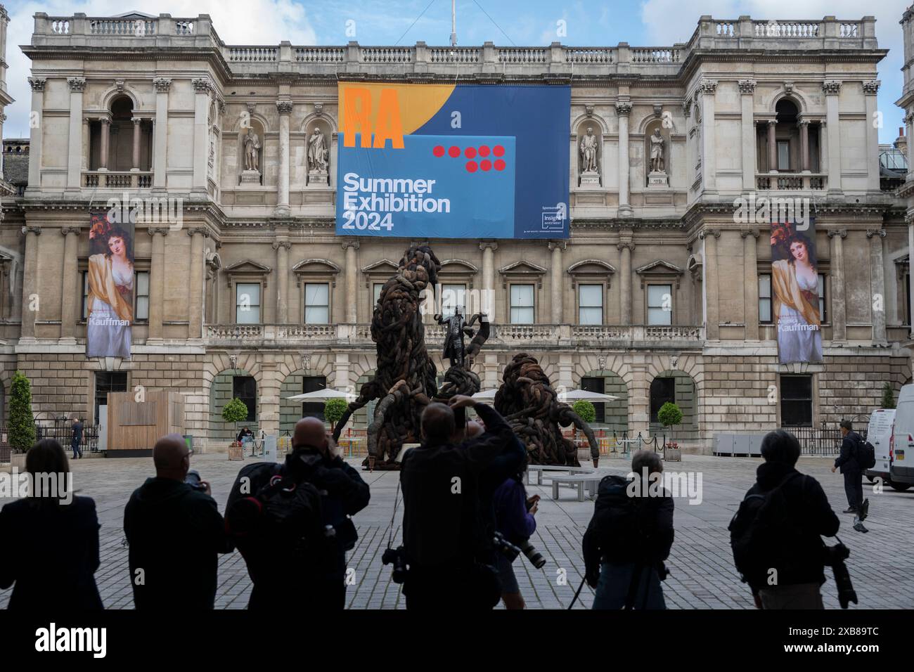 Royal Academy, Londra, Regno Unito. 11 giugno 2024. Quest'anno sono in mostra oltre 1200 opere d'arte nella mostra estiva, tra cui una straordinaria scultura tessile monumentale nel cortile Annenberg (foto) di Nicola Turner, che interagisce con la statua del presidente fondatore della RA, Sir Joshua Reynolds, qui fotografata dalla stampa. La Summer Exhibition presso la RA di Londra, si svolge dal 18 giugno al 18 agosto 2024 ed è la più grande mostra d'arte contemporanea aperta al mondo che si svolge ogni anno senza interruzioni dal 1769. Crediti: Malcolm Park/Alamy Live News Foto Stock