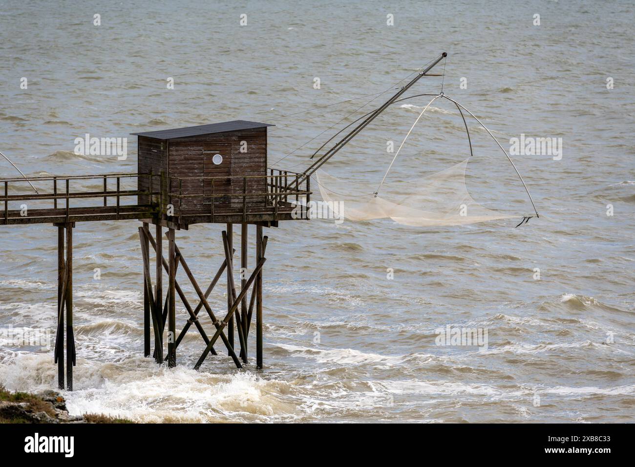 Fisch- und Krabbenfang von Land aus. Sogenanntes Stelzenhaus Carrelet an der Küste von Pornic. Solche gibt es die gesamte Altlantikküste entlang von der VendÃ e aus bis zur Mündung der Gironde und in diese hinein. Die idee ist Jahrhunderte alt und stammt von Fischern, Die nicht das Geld für Boote hatten, BEI Flut wird ein quadratischen Netz auf den Meeresgriund gelassen und während des Einsetzens der ebbe wieder hochgezogen in der Hoffnung, darin Fische - vorzugsweise Schollen, aber auch Aale, andere Fische sowie Krabben zu finden. Der Fang dient heute regelmäßig dem privaten Konsum. Pornic lo Foto Stock