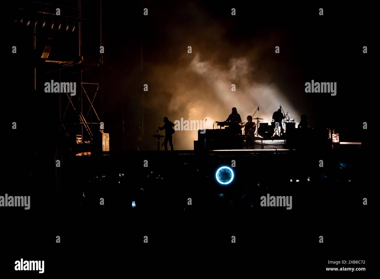 Gruppo di persone in piedi su un palco di notte con il fumo alla deriva nell'aria Foto Stock