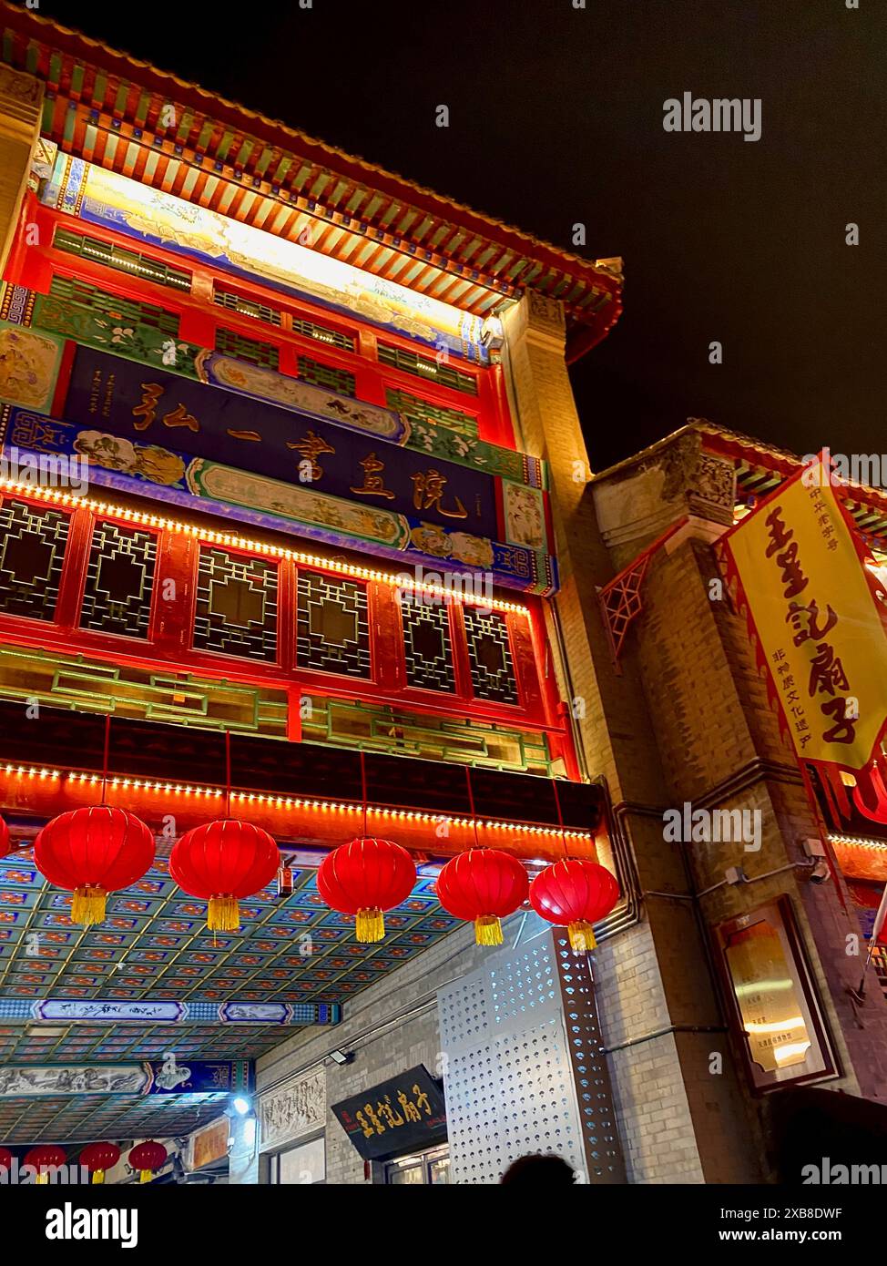 Un edificio adornato di lanterne e circondato da luci accese Foto Stock