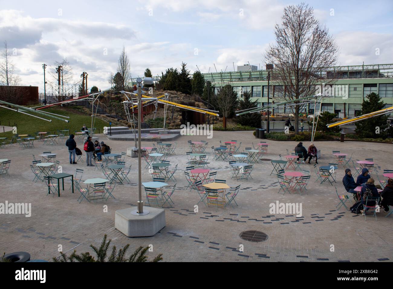 Un gruppo di persone sedute intorno ai tavoli in un ambiente esterno in mattoni a New York, Stati Uniti Foto Stock