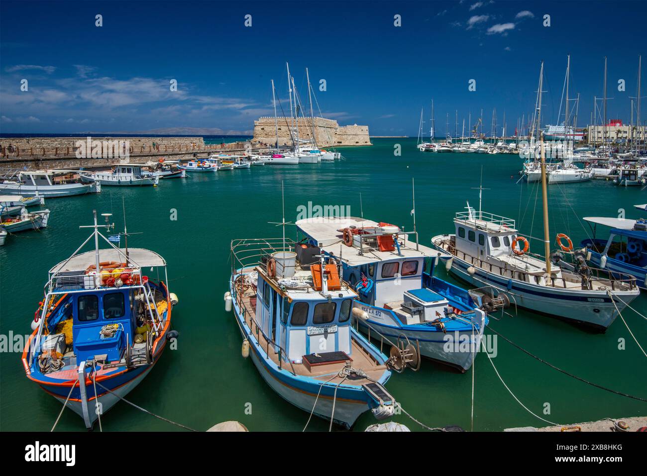 Barche da pesca al porto veneziano, Rocca al Mare fortezza veneziana in lontananza, porto di Heraklion (Iraklio, Iraklion), Creta centrale, Grecia Foto Stock
