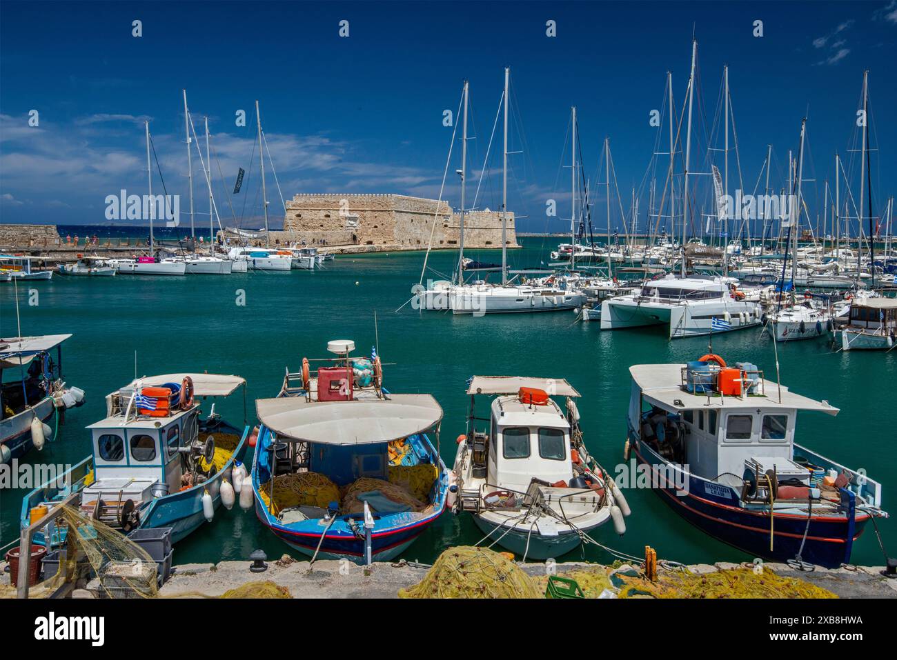 Barche da pesca al porto veneziano, Rocca al Mare fortezza veneziana in lontananza, porto di Heraklion (Iraklio, Iraklion), Creta centrale, Grecia Foto Stock