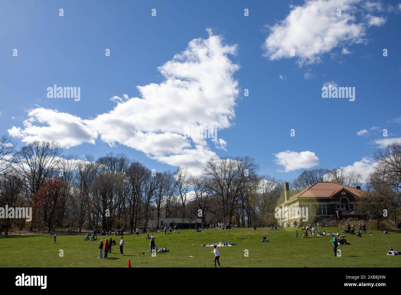 Una folla che si gode di un parco vivace sotto un cielo blu nuvoloso a New York, Stati Uniti Foto Stock
