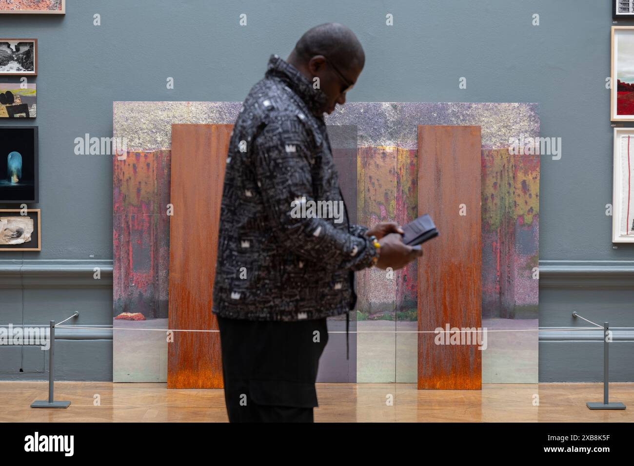 Royal Academy, Londra, Regno Unito. 11 giugno 2024. Quest'anno sono in mostra oltre 1200 opere d'arte, tra cui una straordinaria scultura tessile monumentale nel cortile Annenberg di Nicola Turner, che interagisce con la statua del presidente fondatore della RA, Sir Joshua Reynolds. La Summer Exhibition presso la RA di Londra, si svolge dal 18 giugno al 18 agosto 2024 ed è la più grande mostra d'arte contemporanea aperta al mondo che si svolge ogni anno senza interruzioni dal 1769. Immagine: Riva, acciaio arrugginito, di Roderick Coyne. Crediti: Malcolm Park/Alamy Live News Foto Stock