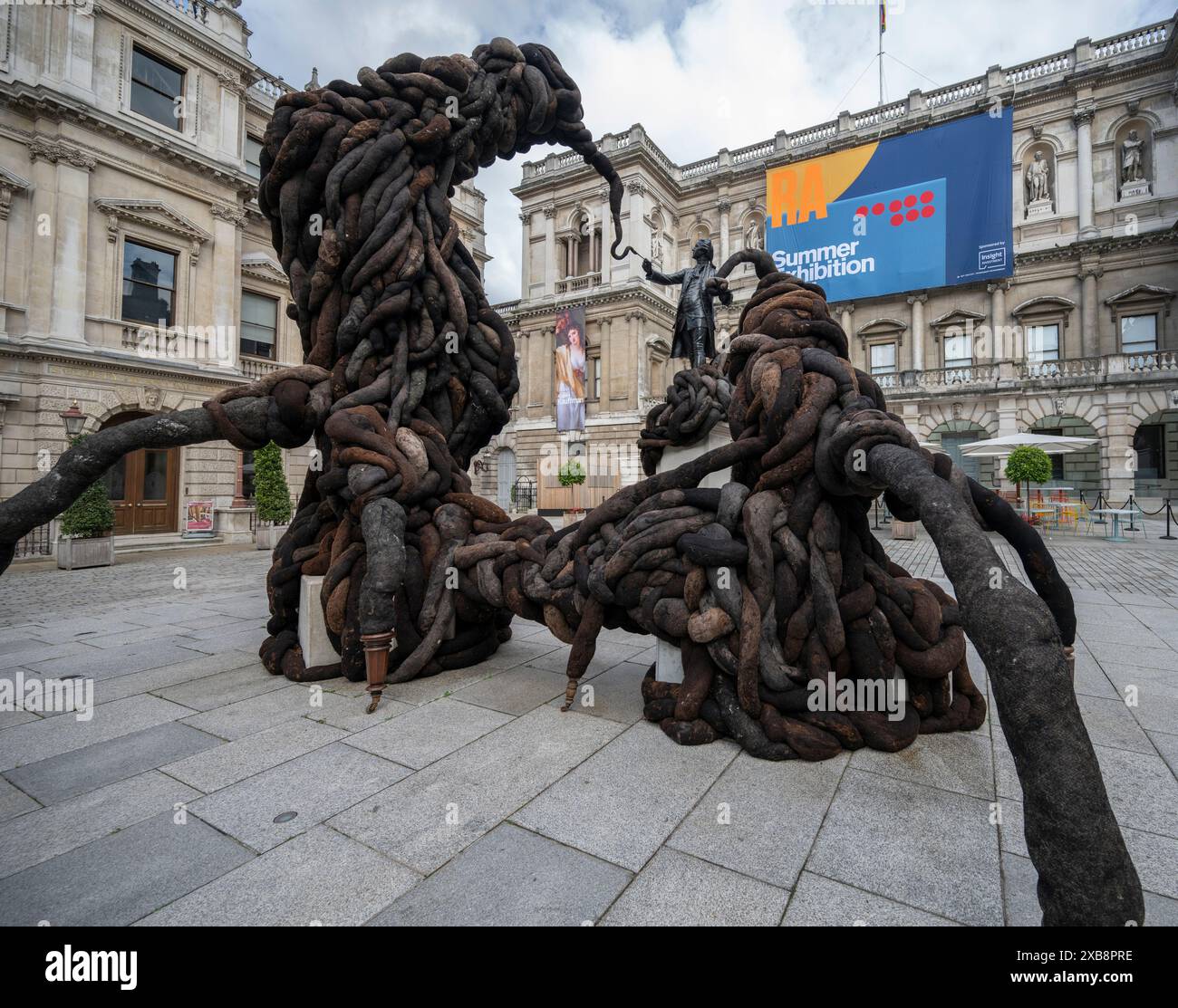 Royal Academy, Londra, Regno Unito. 11 giugno 2024. SOLO NOTIZIE EDITORIALI - quest'anno sono in mostra oltre 1200 opere d'arte nella Mostra estiva, tra cui una straordinaria scultura tessile monumentale nel cortile Annenberg (foto) di Nicola Turner, che interagisce con la statua del presidente fondatore della RA, Sir Joshua Reynolds. La Summer Exhibition presso la RA di Londra, si svolge dal 18 giugno al 18 agosto 2024 ed è la più grande mostra d'arte contemporanea aperta al mondo che si svolge ogni anno senza interruzioni dal 1769. Crediti: Malcolm Park/Alamy Live News Foto Stock