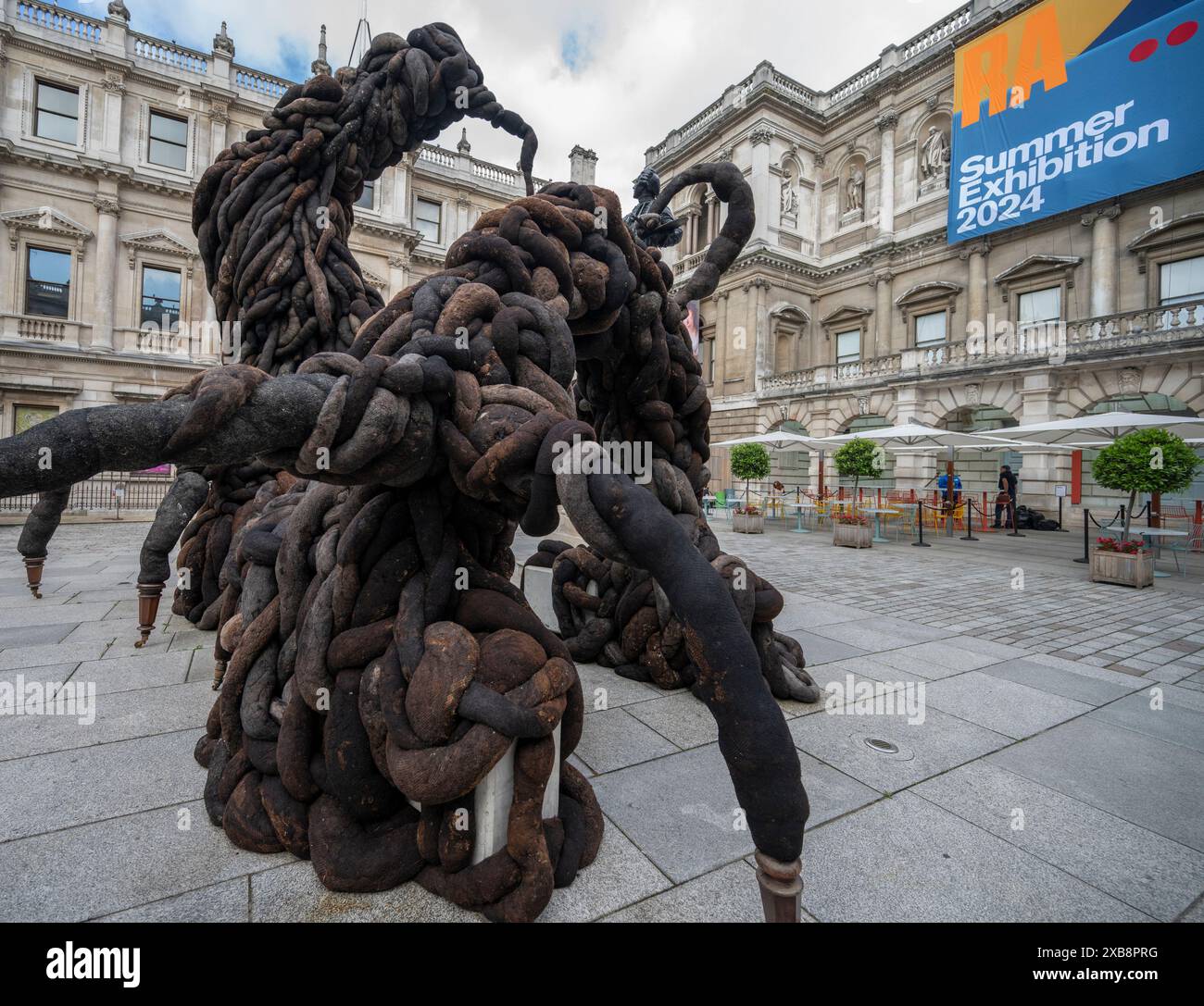 Royal Academy, Londra, Regno Unito. 11 giugno 2024. SOLO NOTIZIE EDITORIALI - quest'anno sono in mostra oltre 1200 opere d'arte nella Mostra estiva, tra cui una straordinaria scultura tessile monumentale nel cortile Annenberg (foto) di Nicola Turner, che interagisce con la statua del presidente fondatore della RA, Sir Joshua Reynolds. La Summer Exhibition presso la RA di Londra, si svolge dal 18 giugno al 18 agosto 2024 ed è la più grande mostra d'arte contemporanea aperta al mondo che si svolge ogni anno senza interruzioni dal 1769. Crediti: Malcolm Park/Alamy Live News Foto Stock