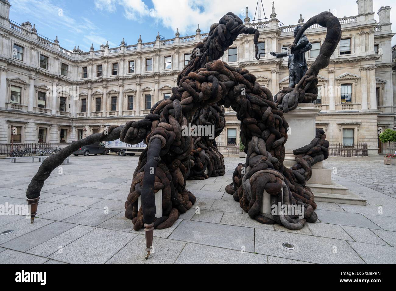 Royal Academy, Londra, Regno Unito. 11 giugno 2024. SOLO NOTIZIE EDITORIALI - quest'anno sono in mostra oltre 1200 opere d'arte nella Mostra estiva, tra cui una straordinaria scultura tessile monumentale nel cortile Annenberg (foto) di Nicola Turner, che interagisce con la statua del presidente fondatore della RA, Sir Joshua Reynolds. La Summer Exhibition presso la RA di Londra, si svolge dal 18 giugno al 18 agosto 2024 ed è la più grande mostra d'arte contemporanea aperta al mondo che si svolge ogni anno senza interruzioni dal 1769. Crediti: Malcolm Park/Alamy Live News Foto Stock