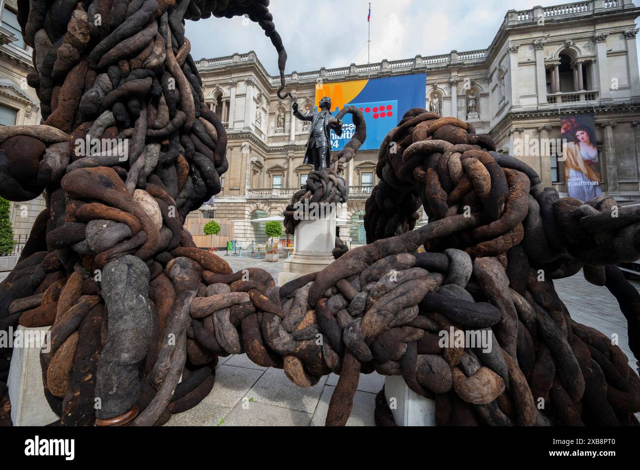 Royal Academy, Londra, Regno Unito. 11 giugno 2024. SOLO NOTIZIE EDITORIALI - quest'anno sono in mostra oltre 1200 opere d'arte nella Mostra estiva, tra cui una straordinaria scultura tessile monumentale nel cortile Annenberg (foto) di Nicola Turner, che interagisce con la statua del presidente fondatore della RA, Sir Joshua Reynolds. La Summer Exhibition presso la RA di Londra, si svolge dal 18 giugno al 18 agosto 2024 ed è la più grande mostra d'arte contemporanea aperta al mondo che si svolge ogni anno senza interruzioni dal 1769. Crediti: Malcolm Park/Alamy Live News Foto Stock