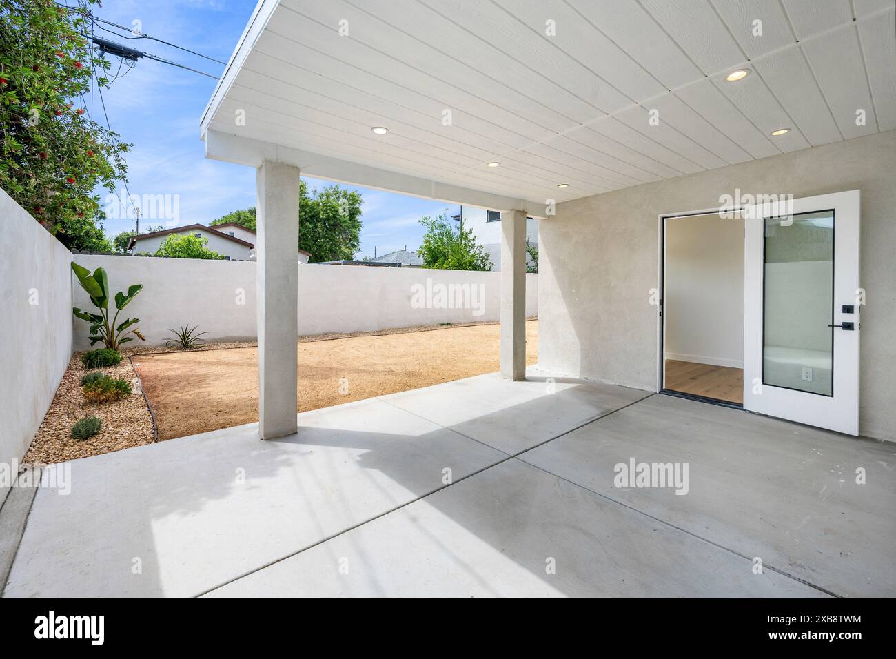 Patio all'aperto con pareti bianche e colonne di cemento Foto Stock