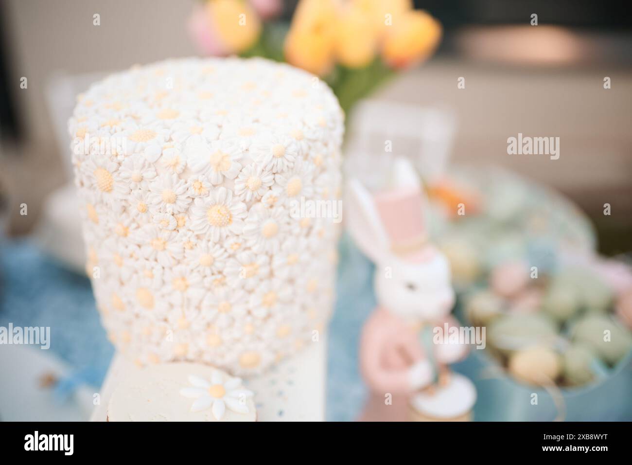 Un primo piano di margherite fondenti che decorano una deliziosa torta Foto Stock