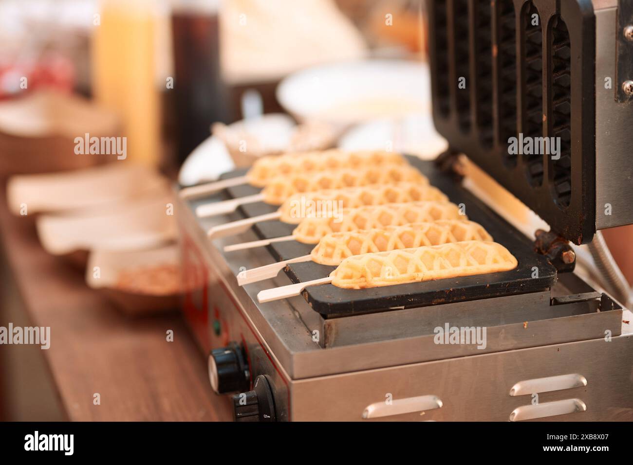 Una macchina elettrica per preparare waffle con bastoncini Foto Stock