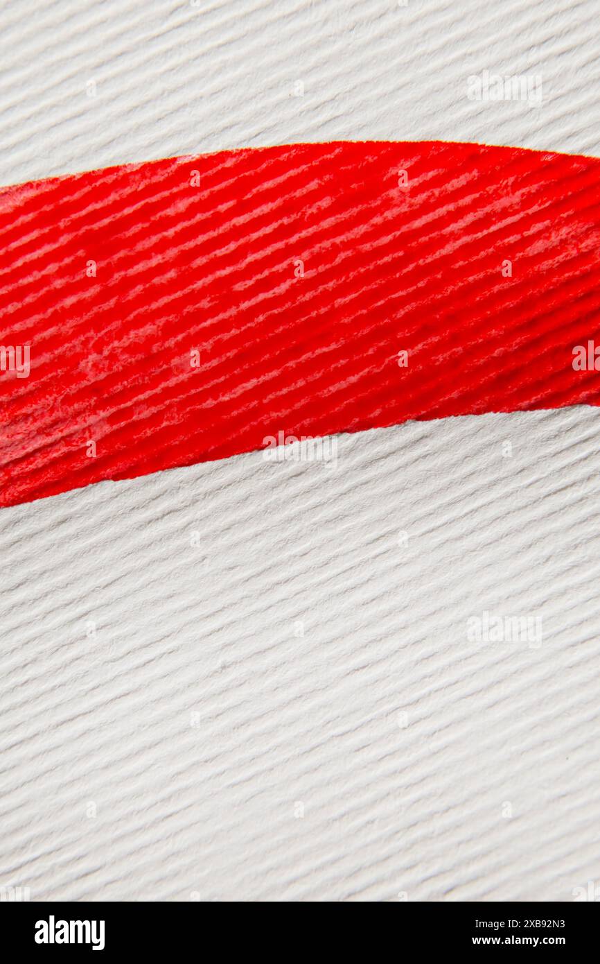 sfondo del titolo astratto: primo piano del tratto di vernice rossa su carta a strisce bianche Foto Stock