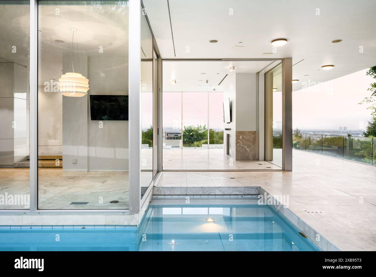 Camera interna con piscina coperta e porte che si aprono su un ponte Foto Stock