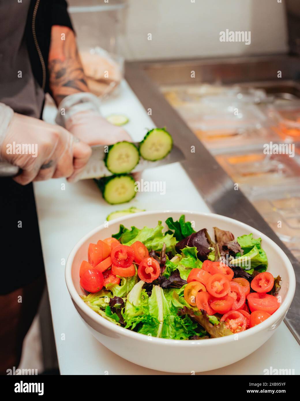 Una persona che trita verdure fresche per un'insalata in un recipiente in primo piano Foto Stock