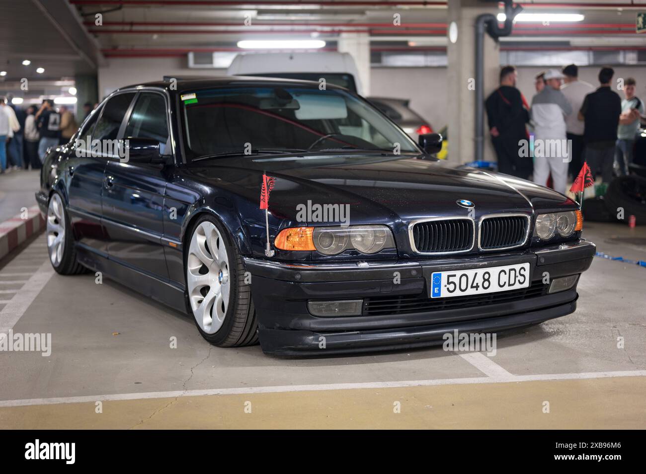 Auto tedesca BMW E38 di colore scuro con la bandiera dell'aquila imperiale tedesca sui parafanghi anteriori. Si tratta di un'aquila a due teste su sfondo rosso Foto Stock