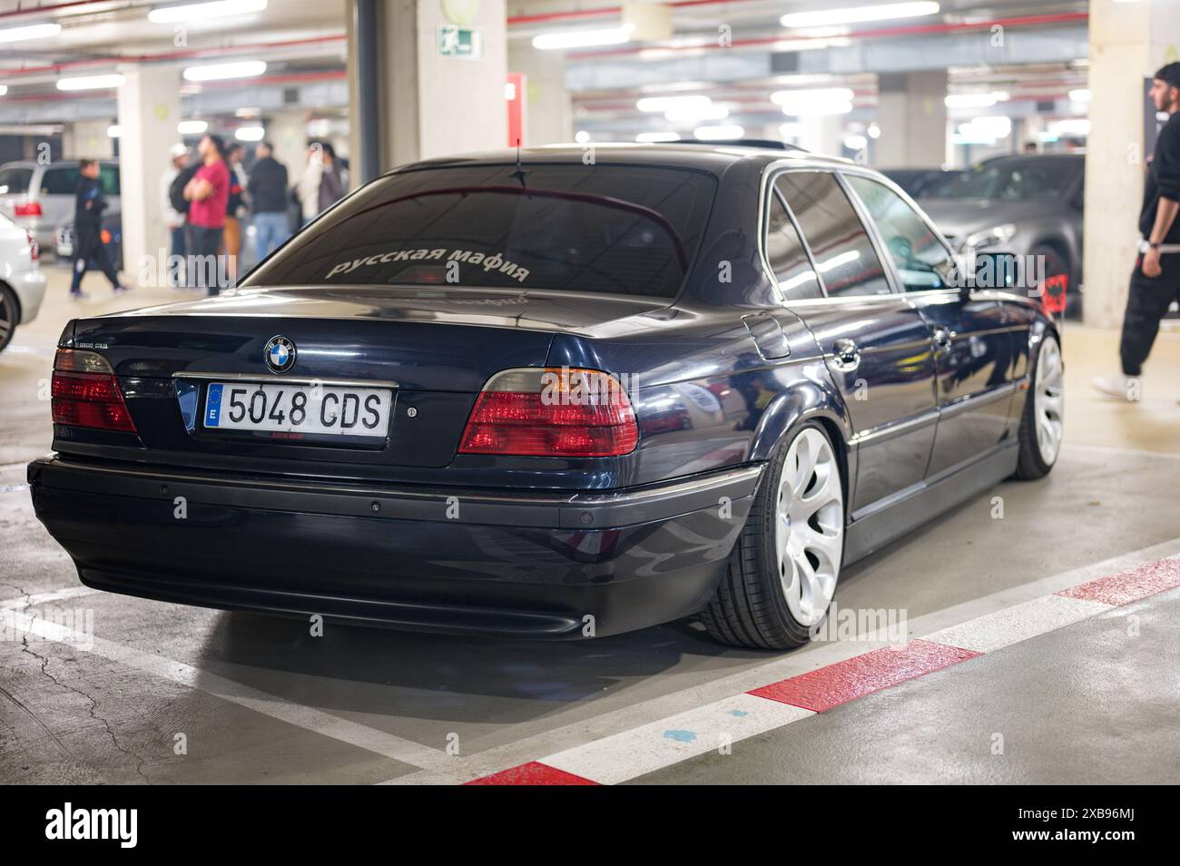 Auto tedesca classica BMW E38 di colore scuro con la bandiera dell'aquila imperiale tedesca sui parafanghi anteriori. Si tratta di un'aquila a due teste su sfondo rosso Foto Stock
