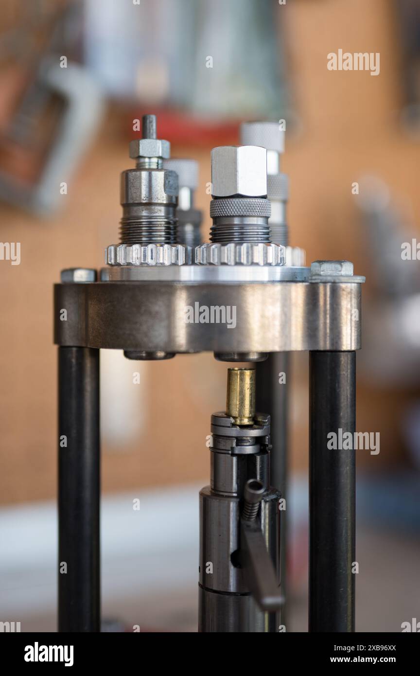 Dettaglio del processo di Belling o espansione di un contenitore da 9 mm nella pressa di ricarica con lo stampo di espansione per poter posizionare il proiettile Foto Stock