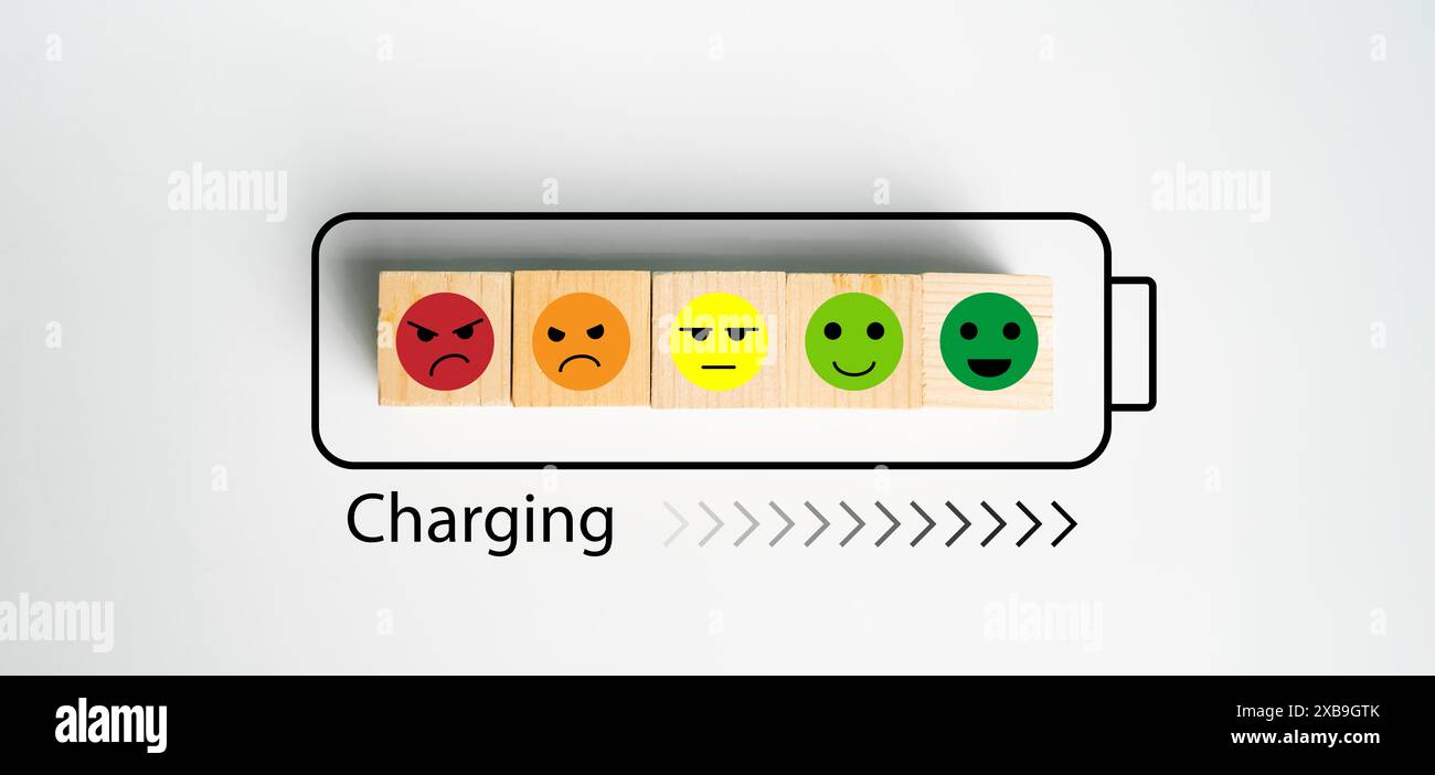 Giornata mondiale di salute mentale, emozioni blocchi di legno in stato carica batteria, arrabbiato, indifferente, sorridere, pensare positivo, migliorare la Q emotiva ed emotiva Foto Stock