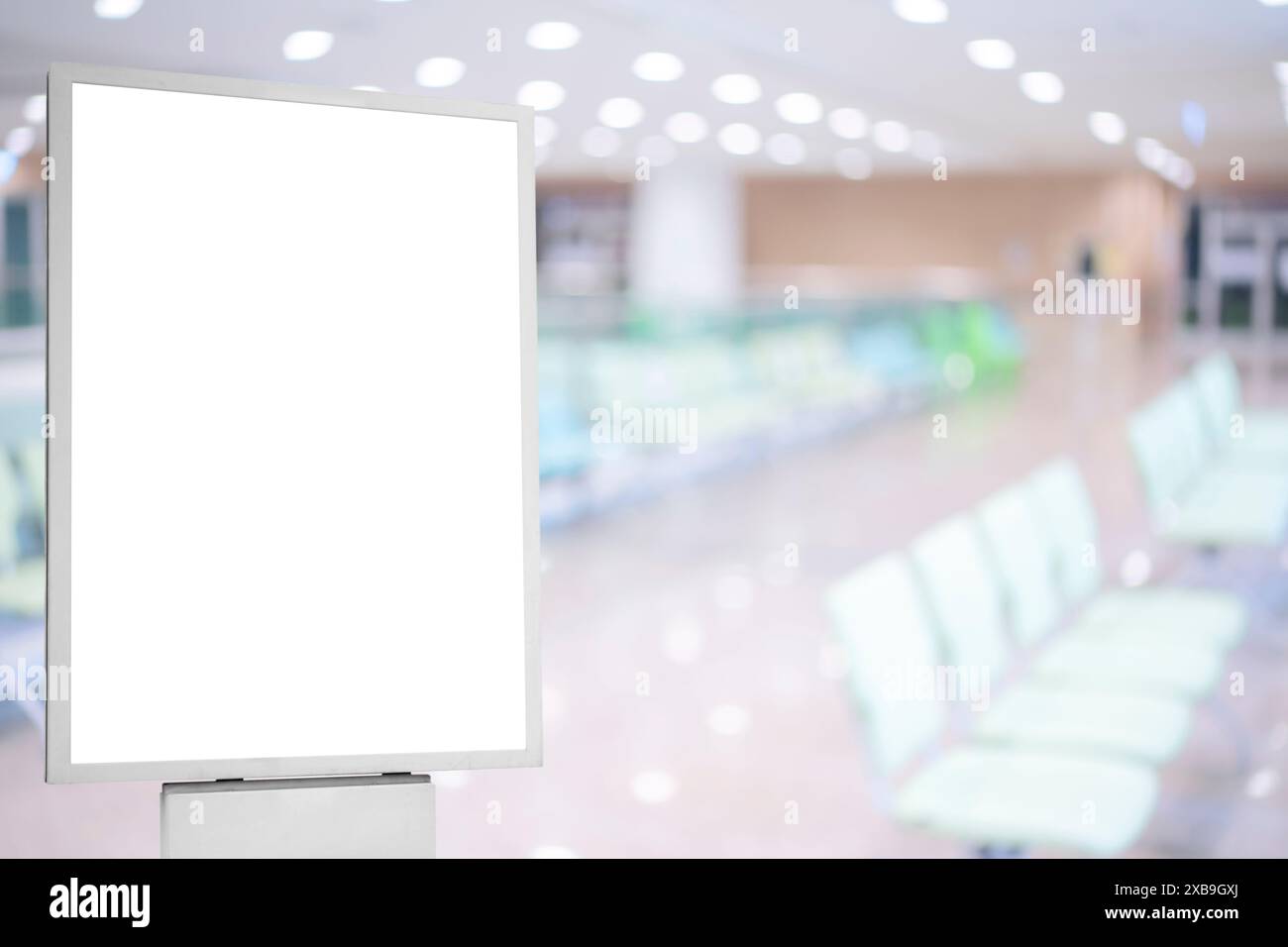 Un mockup di un poster bianco vuoto sulla parete in moderna sala d'attesa dell'ospedale con comode sedie e attrezzature mediche. poster vuoto bianco Foto Stock