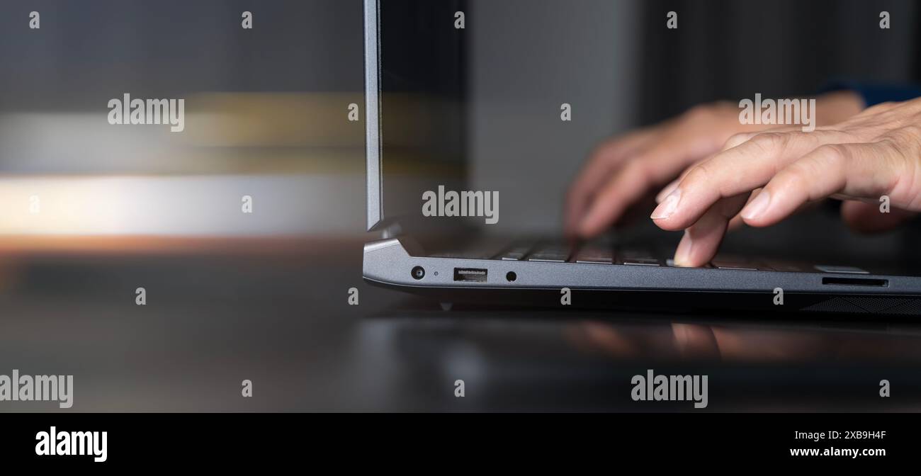 Primo piano delle mani di un uomo d'affari che digita sul computer portatile su un tavolo di vetro con un uomo d'affari Reflection che lavora utilizzando un computer portatile navigare nell'inter Foto Stock