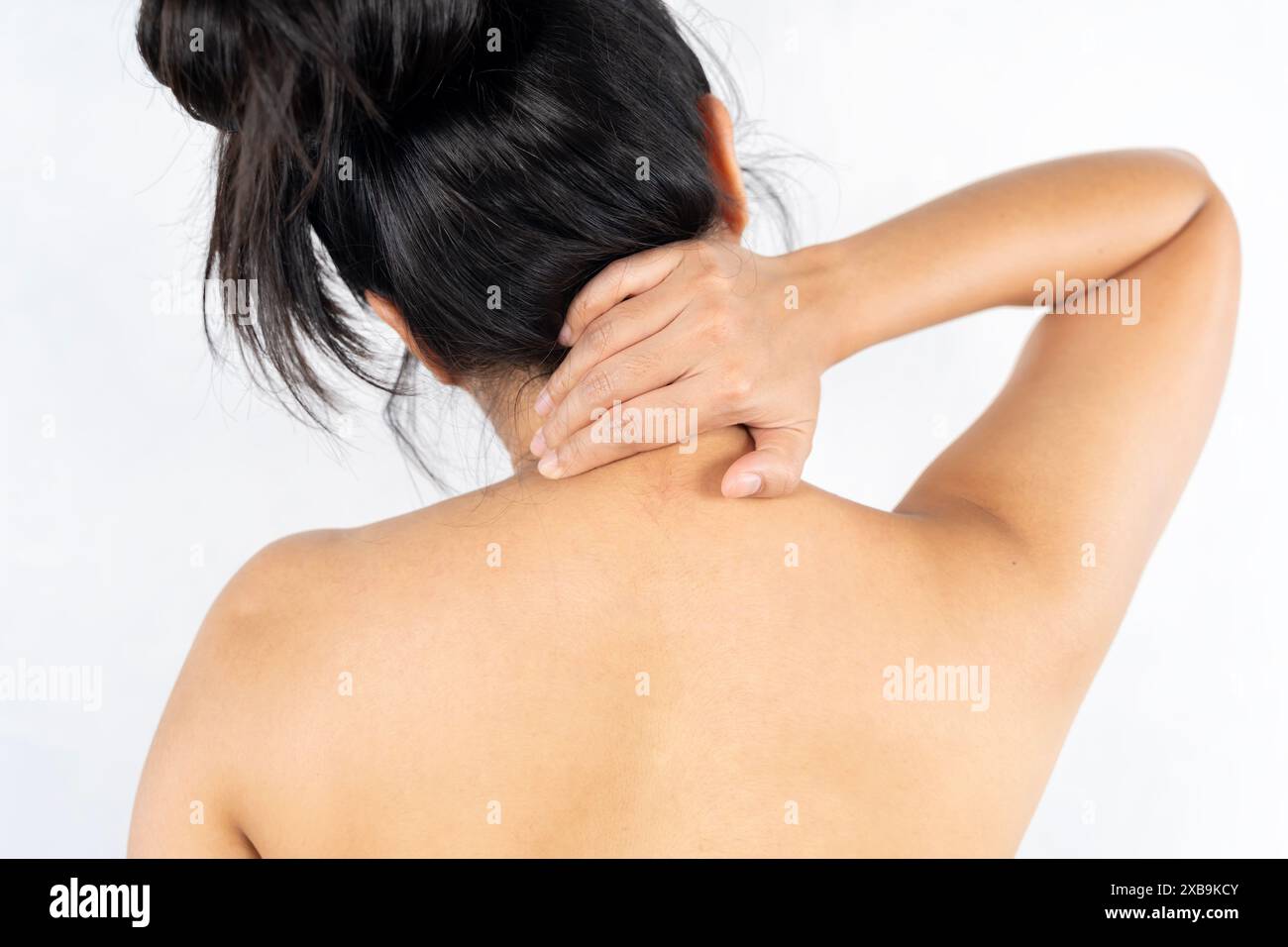 Donna che sfrega dolori alla schiena. Donna con dolore al collo che lo tiene con entrambe le braccia con espressione dolorosa. Foto Stock