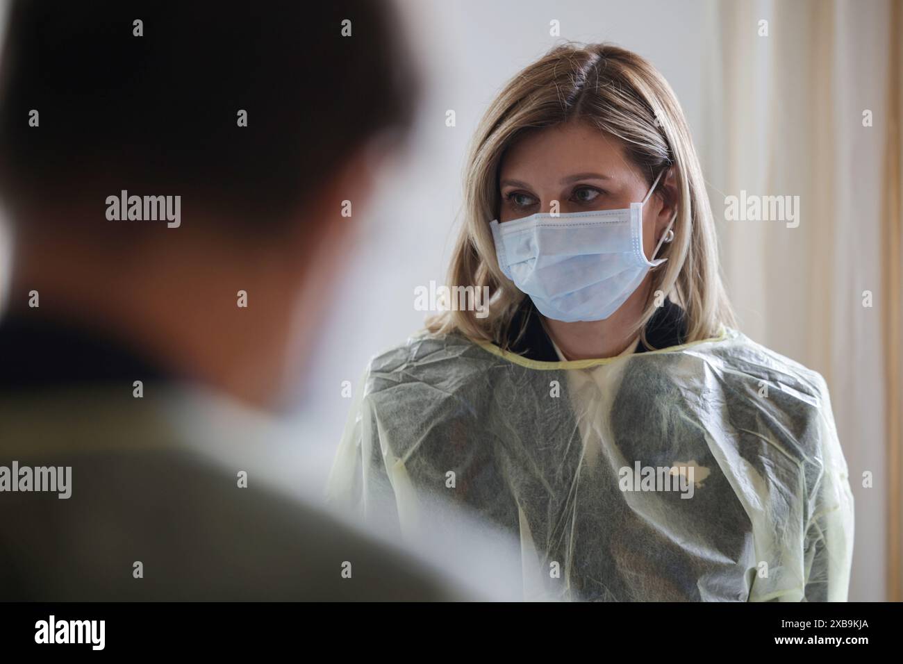 Berlino, Germania. 11 giugno 2024. Olena Selenska, First Lady dell'Ucraina, indossa una maschera protettiva e una tuta protettiva per proteggere un paziente dai germi durante una visita all'ospedale Bundeswehr di Berlino. I soldati ucraini sono curati nell'ospedale della Bundeswehr come parte del meccanismo di protezione civile dell'UE. Crediti: Hannes Albert/dpa/Alamy Live News Foto Stock