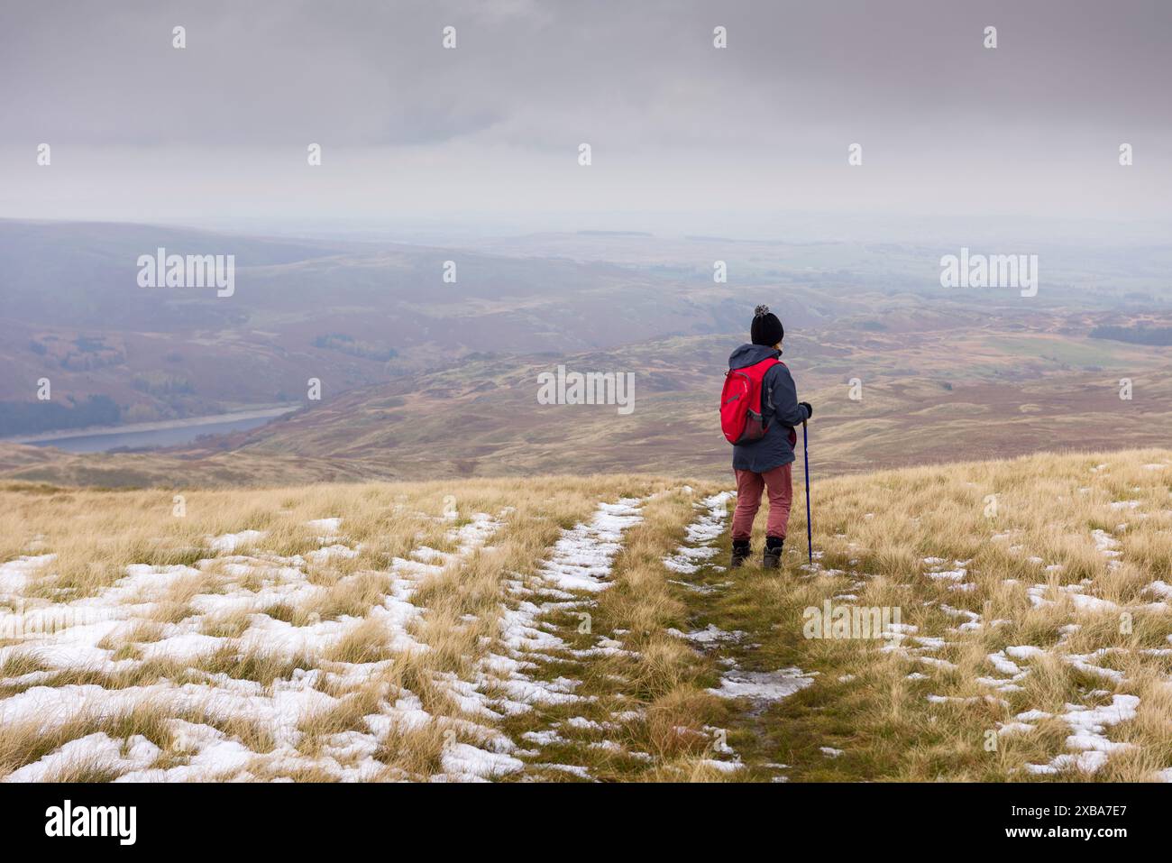 Una camminatrice che si gode la vista sul Mardale Common e sul lago artificiale Haweswater da Selside Pike nel Lake District National Park, Cumbria, Inghilterra. Foto Stock