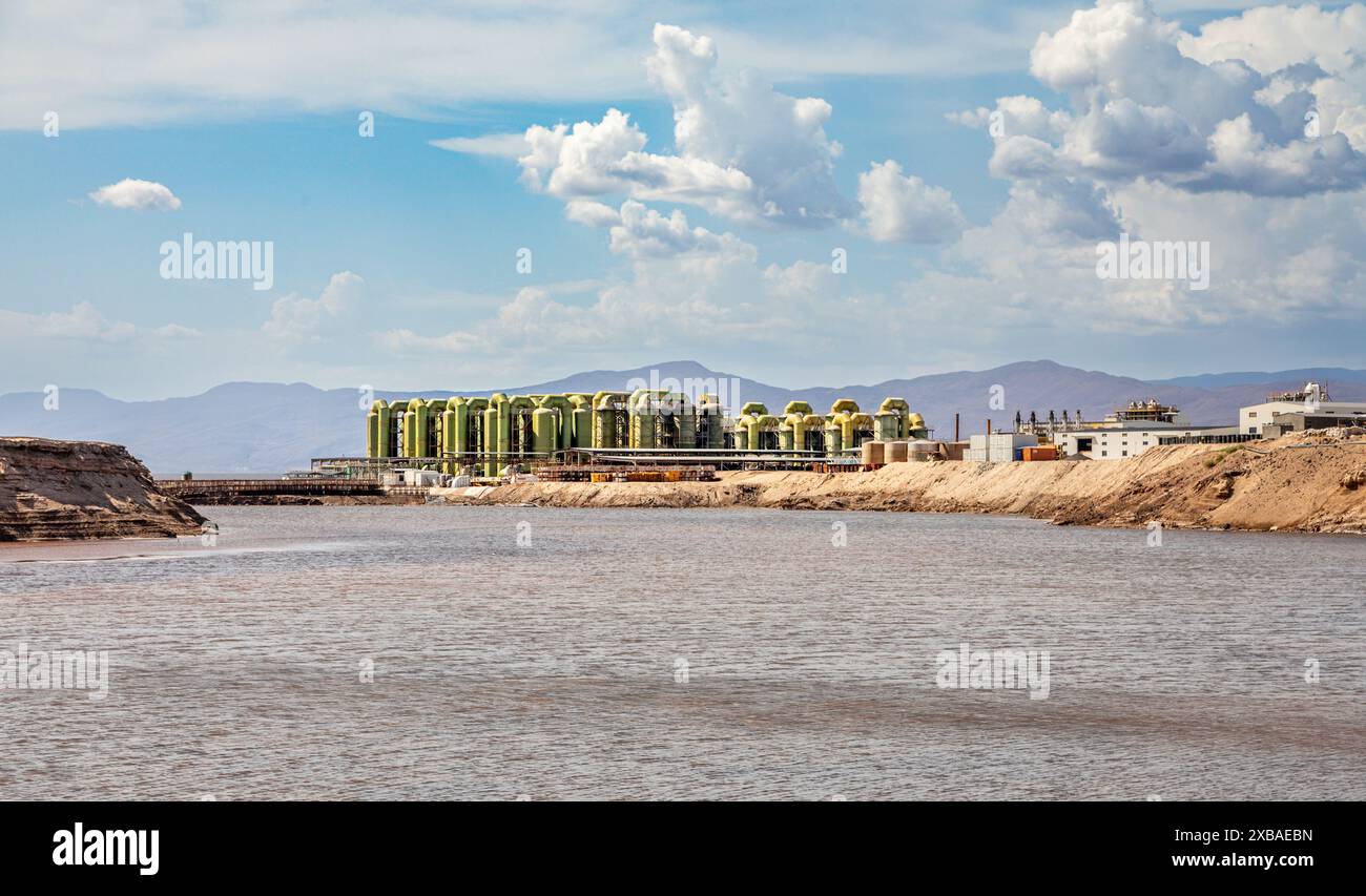 Acque di lago salato LAC Assal con una fabbrica di estrazione del sale sullo sfondo, il punto più basso dell'Africa, regione di Tadjourah, Gibuti Foto Stock