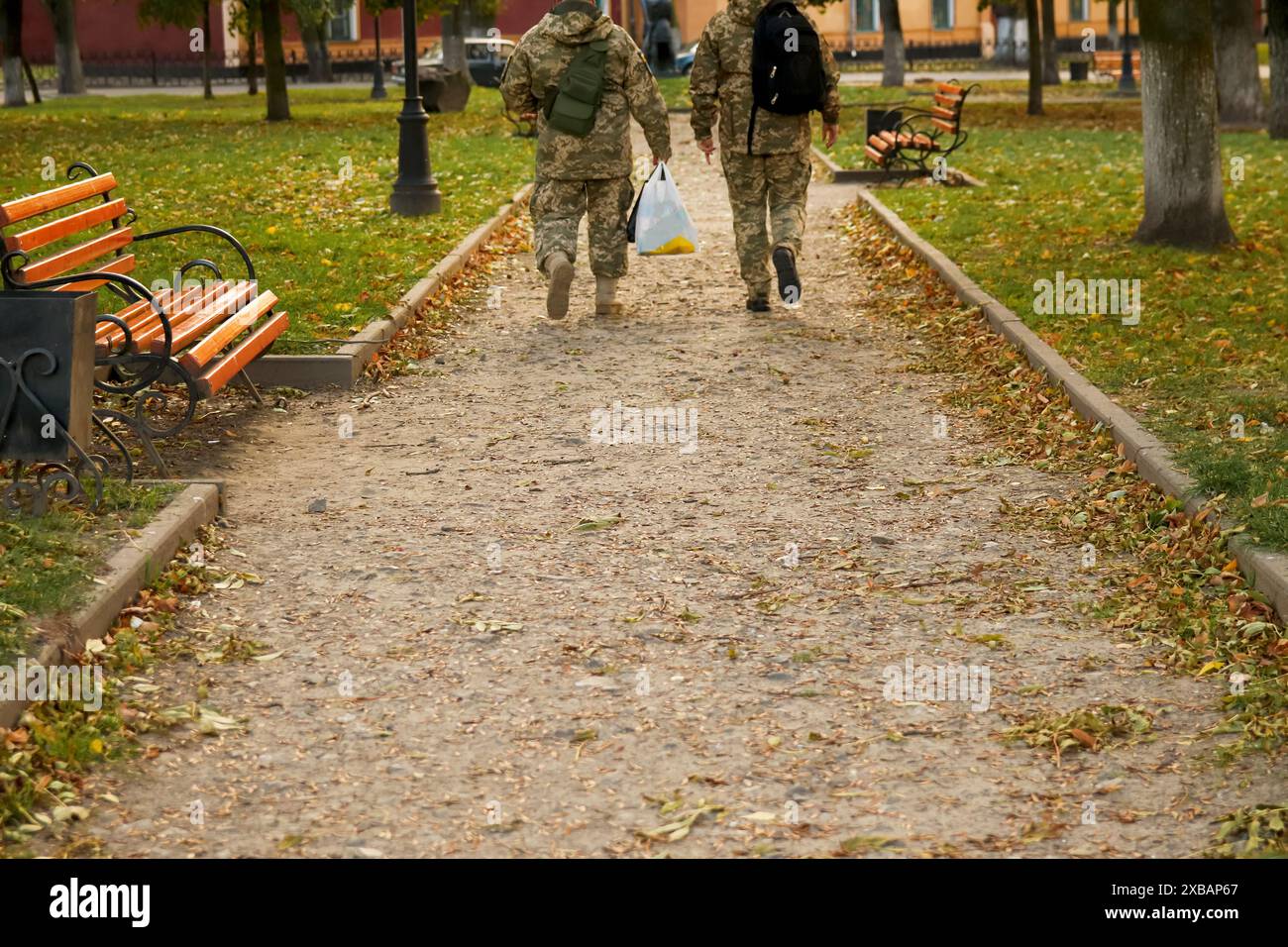 Soldati ucraini in un parco durante l'autunno, indossando uniformi militari. Scena autunnale con personale dell'esercito ucraino in uniforme che pattuglia un parco. Guerra in corso Foto Stock