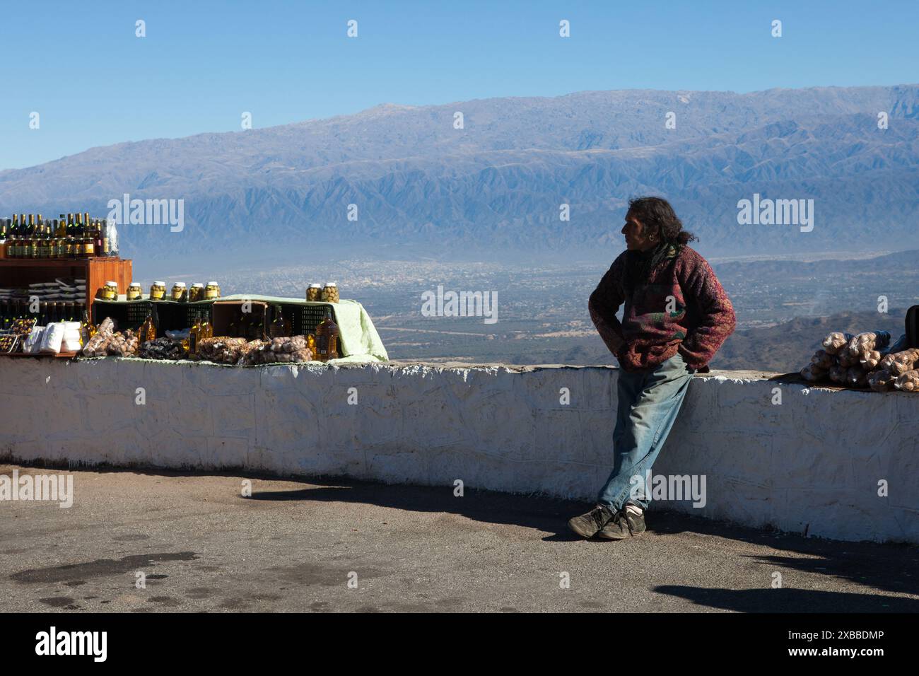 Salta. Argentina. uomo indigeno locale, venditore ambulante, che vende cibo fatto in casa fuori su una strada per passare gli autobus turistici Foto Stock