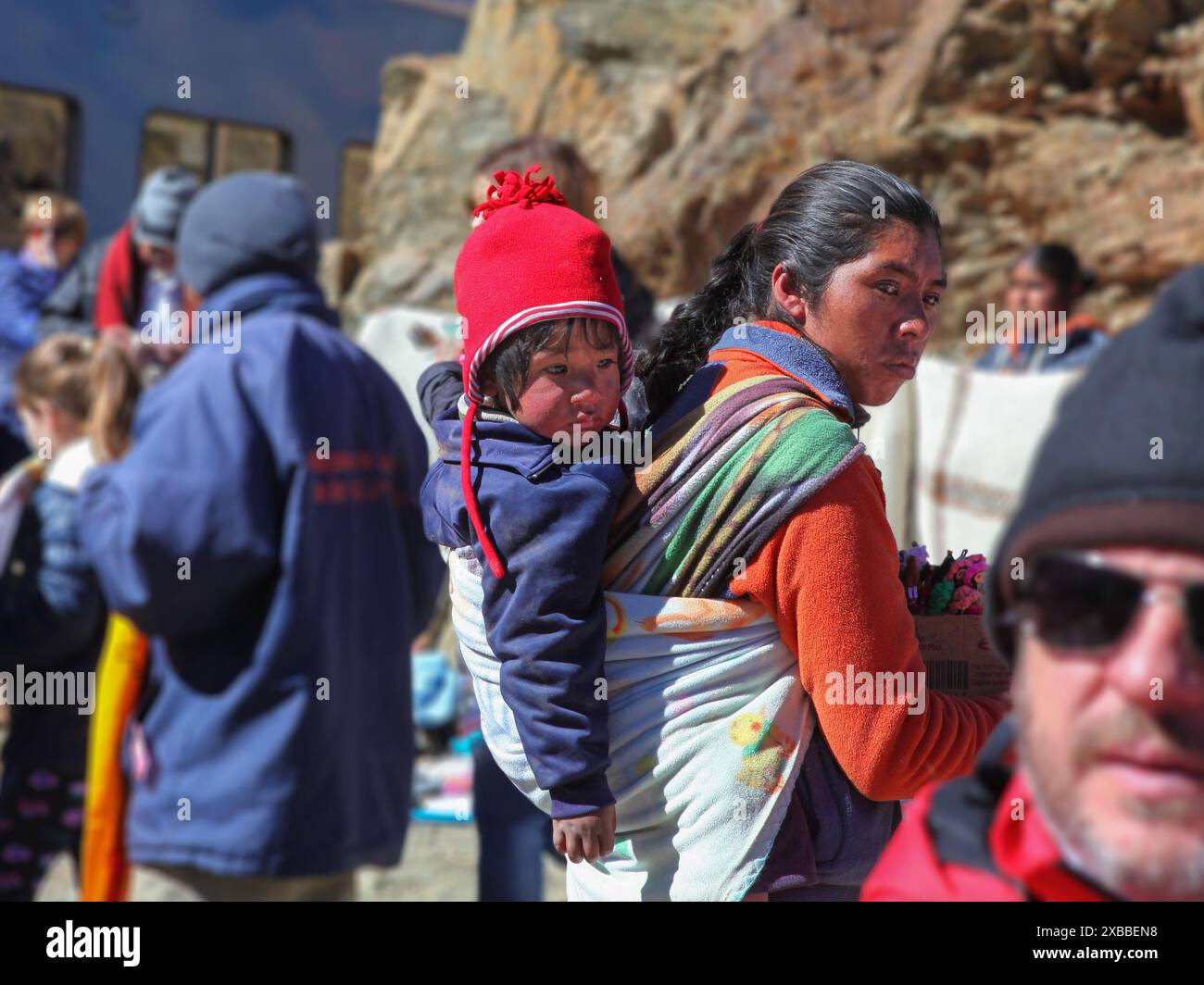 San Antonio de los Cobres. Salta. Argentina.indigenous donne con bambino in portabagagli alla stazione treno per le nuvole ,. vendere souvenir fatti a mano. Foto Stock