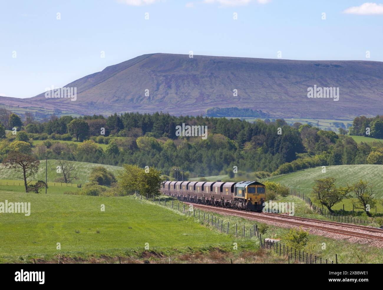 Locomotiva Freightliner classe 66 66520 che trasporta un treno merci a carbone "Merry Go Round" sulla ferrovia Blackburn-Hellifield, Pendle Hill è dietro Foto Stock