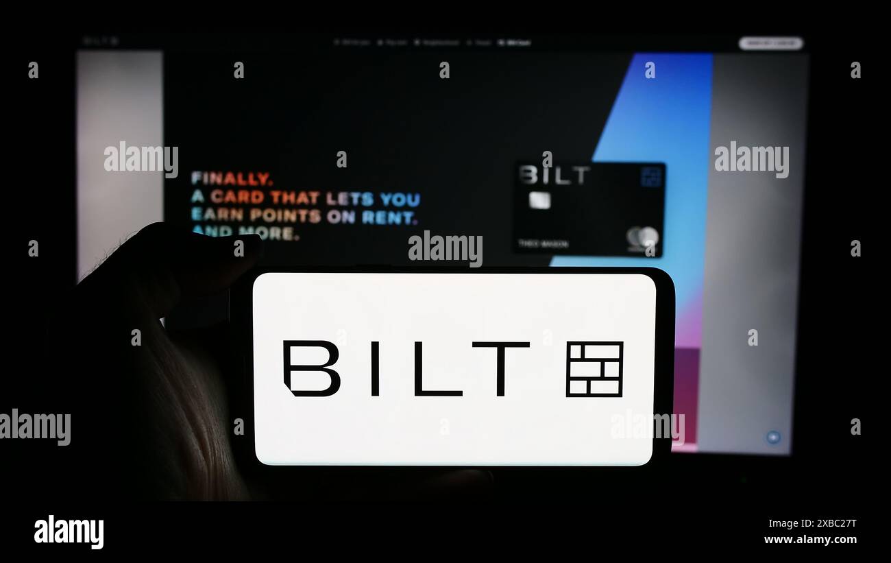 Persona che detiene un cellulare con il logo della società di noleggio statunitense Bilt Technologies Inc. Di fronte alla pagina Web aziendale. Mettere a fuoco il display del telefono. Foto Stock