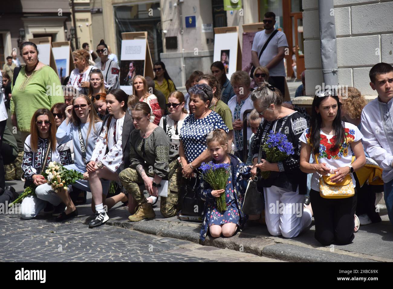 Le persone si inginocchiano durante la cerimonia funebre della paramedica Iryna Tsybukh. Iryna Tsybukh è nata il 1998 giugno a Leopoli, Ucraina, è stata anche una figura pubblica Ucraina, giornalista, direttore di dipartimento della direzione di radiodiffusione regionale della compagnia televisiva pubblica nazionale e radio dell'Ucraina, paramedica del battaglione medico "Hospitaliers". Durante l'invasione su vasta scala della Russia in Ucraina, si unì al battaglione medico volontario "Hospitaliers", dove prese la posizione di senior del 5 ° equipaggio. Il 29 maggio 2024 fu uccisa durante la rotazione nel direc di Charkiv Foto Stock